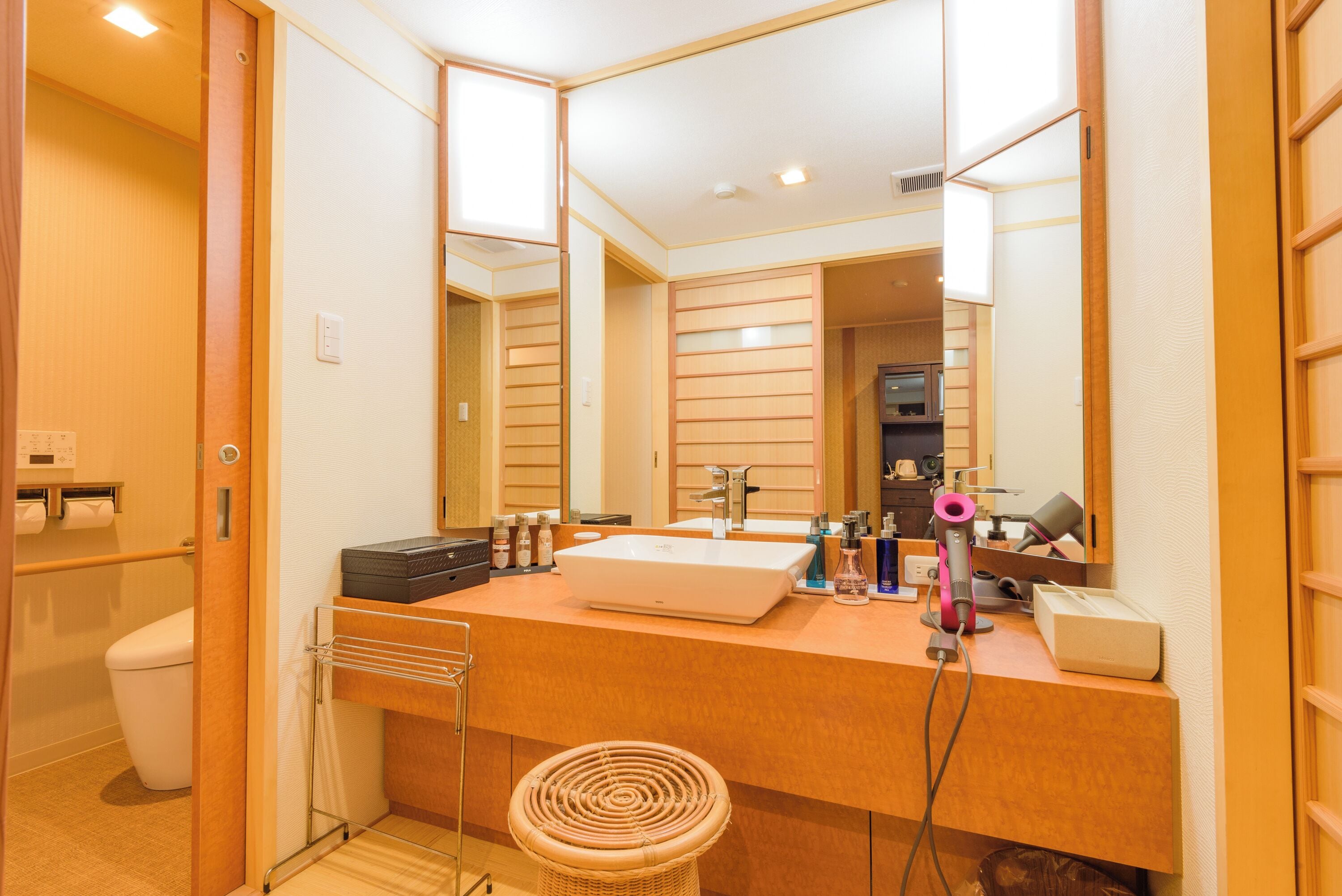 Un bagno moderno con uno specchio grande, un lavandino e un asciugacapelli.