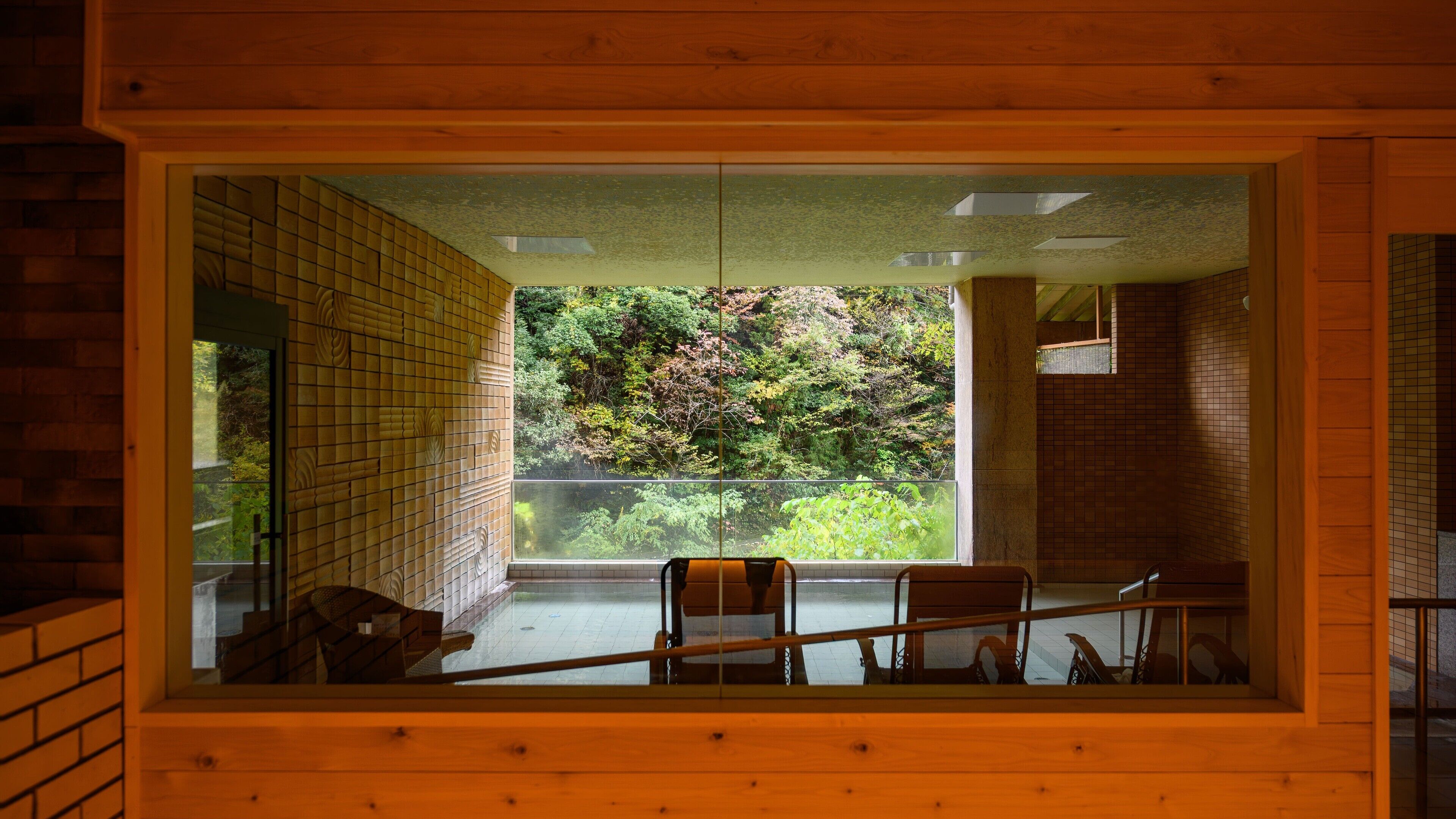 A room with a large window overlooking a lush garden.
