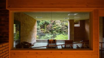 A room with a large window overlooking a lush garden.
