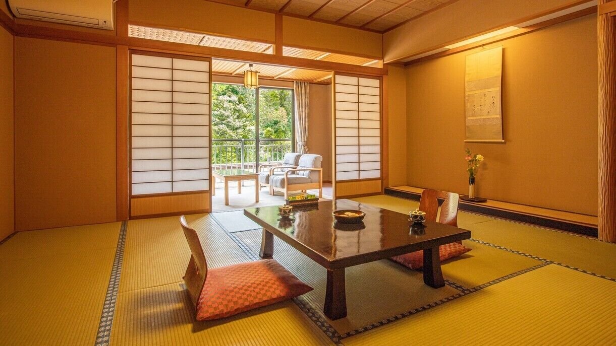 Ett traditionellt japanskt rum med tatamimattor på golvet, ett lågt bord och skjutdörrar.