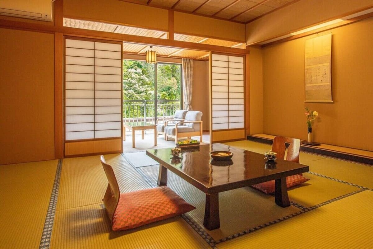 Ett traditionellt japanskt rum med tatamimattor på golvet, ett lågt bord och skjutdörrar.