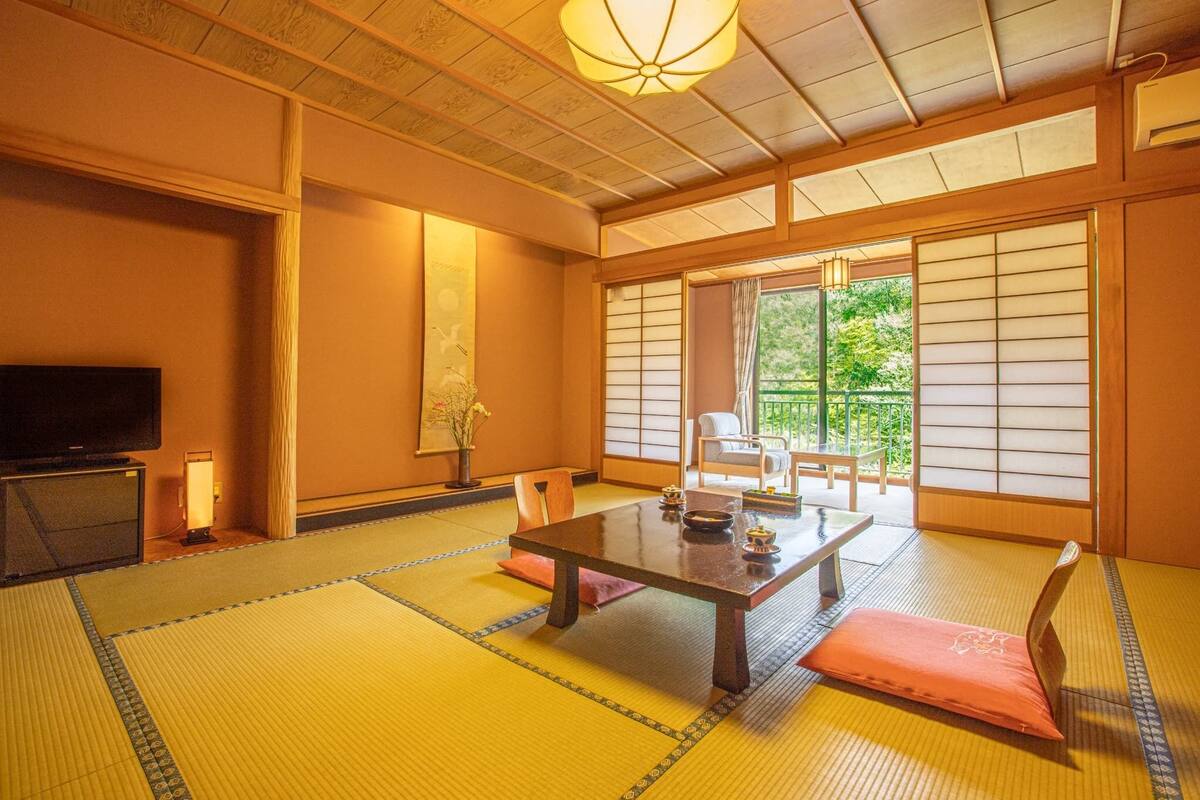 A traditional Japanese room with tatami flooring, a low table, and sliding doors.