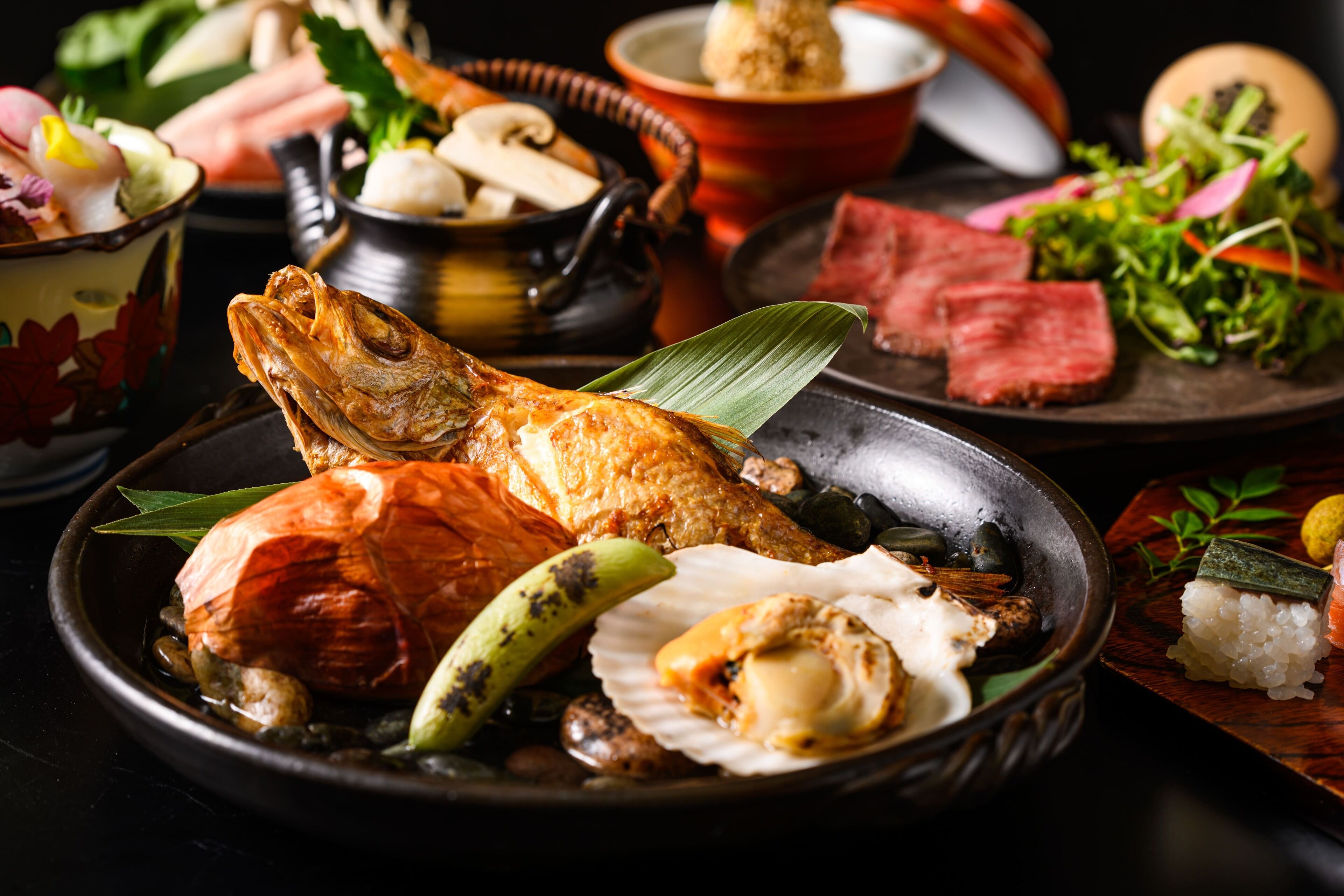 A variety of dishes including fish, vegetables, and rice, presented on a table.