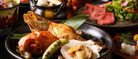 A variety of dishes including fish, vegetables, and rice, presented on a table.