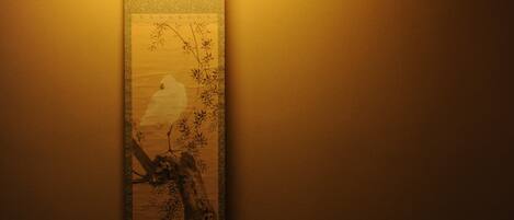 A wall with a vertical artwork depicting a tree and branches.
