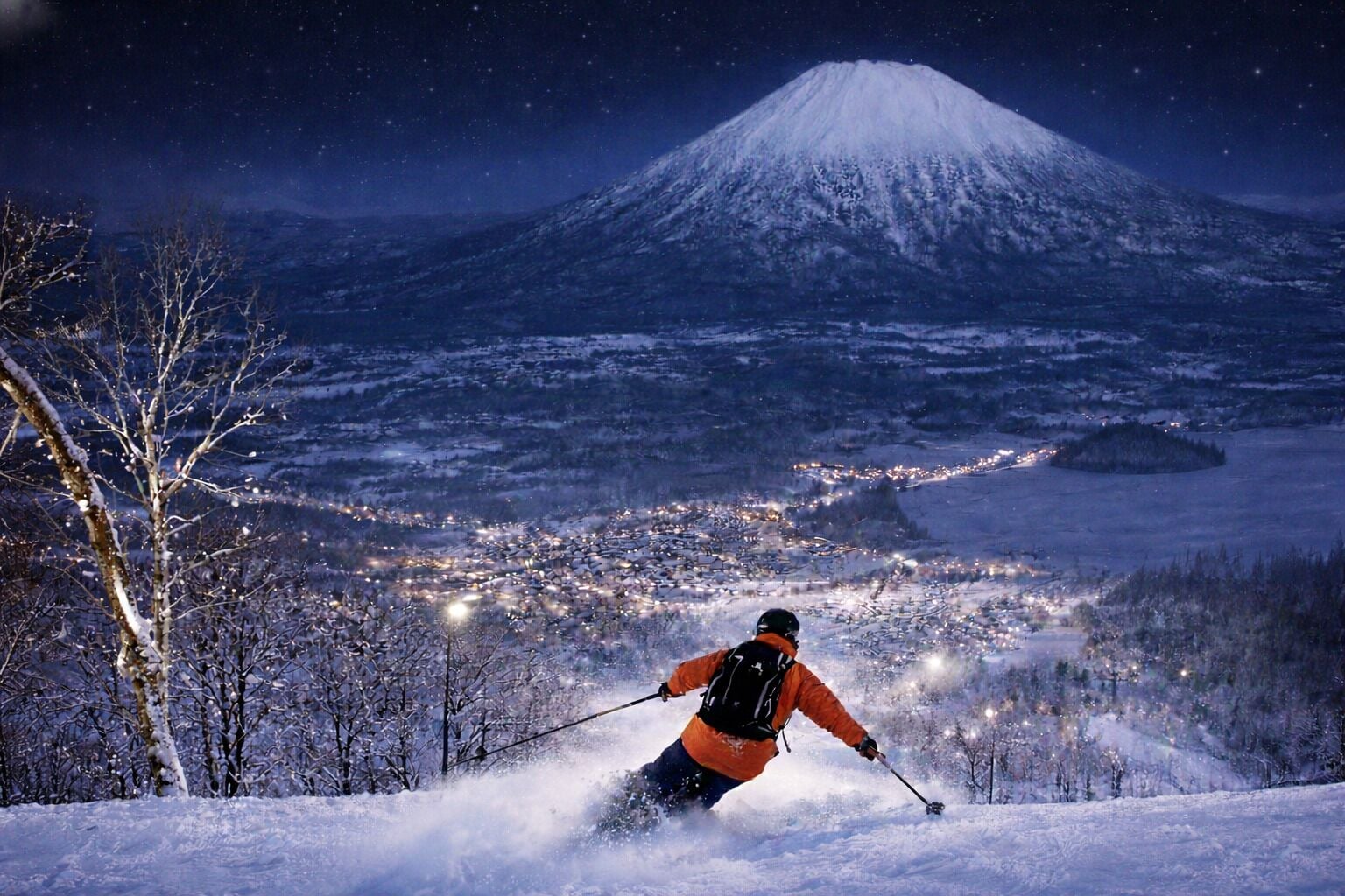 A person skiing down a snowy slope with a mountain in the background.