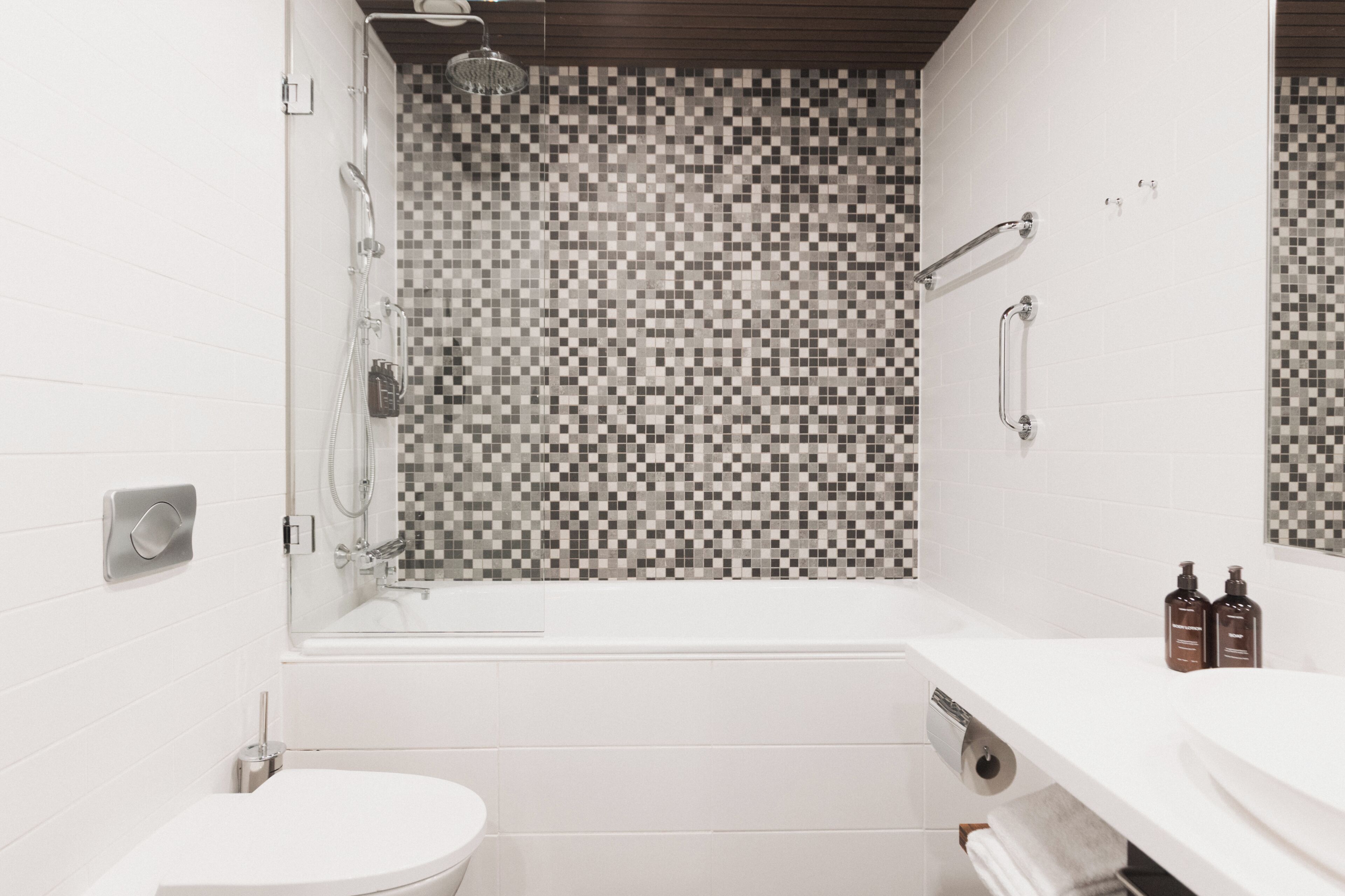 A modern bathroom with a shower, toilet, and sink.