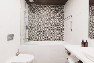 Un baño moderno con ducha, inodoro y lavamanos.