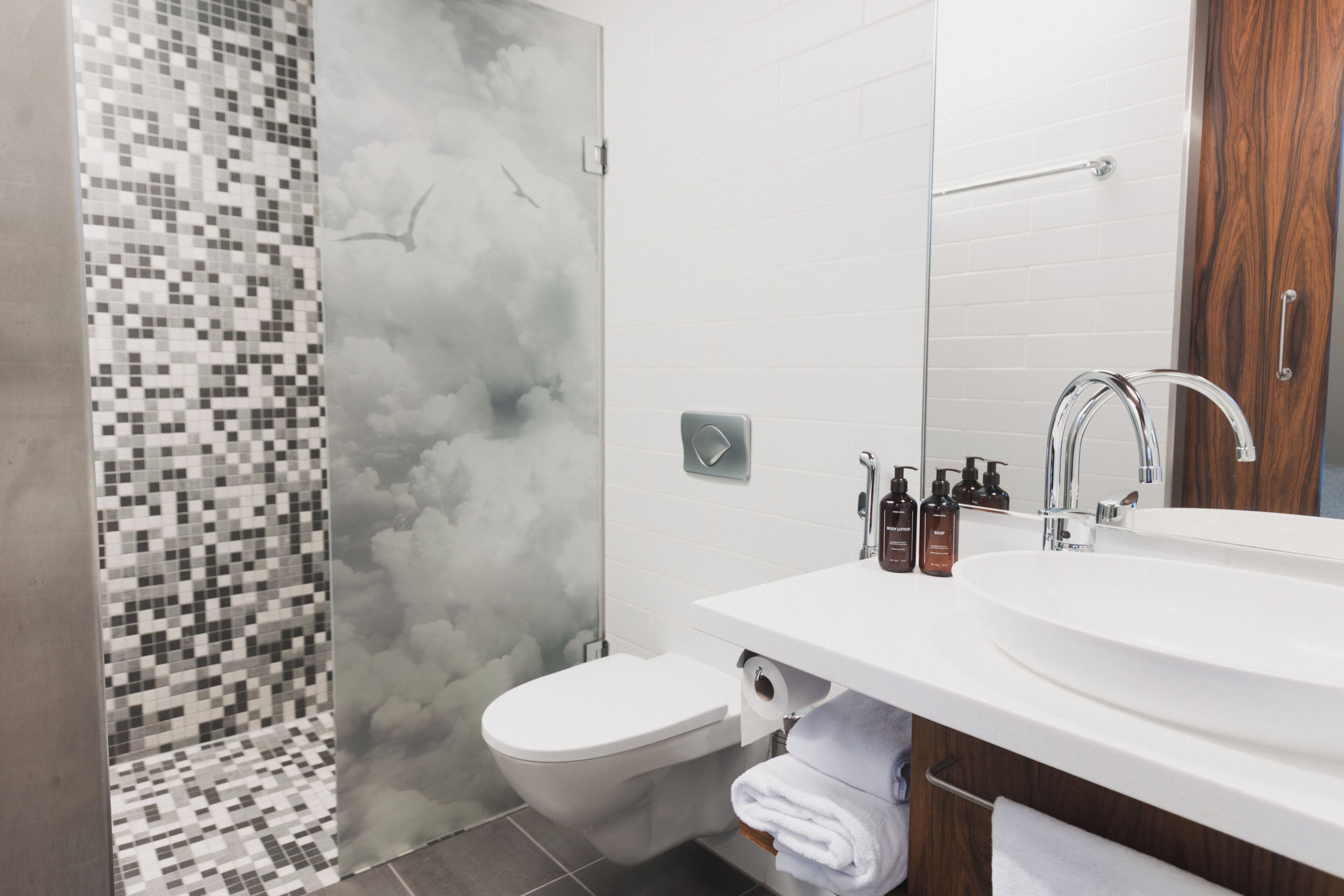 Une salle de bain moderne équipée d’une douche, de toilettes et d’un lavabo.