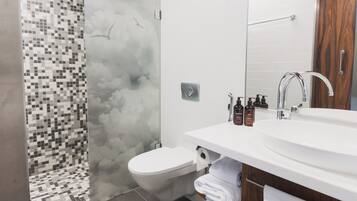 Une salle de bain moderne équipée d’une douche, de toilettes et d’un lavabo.