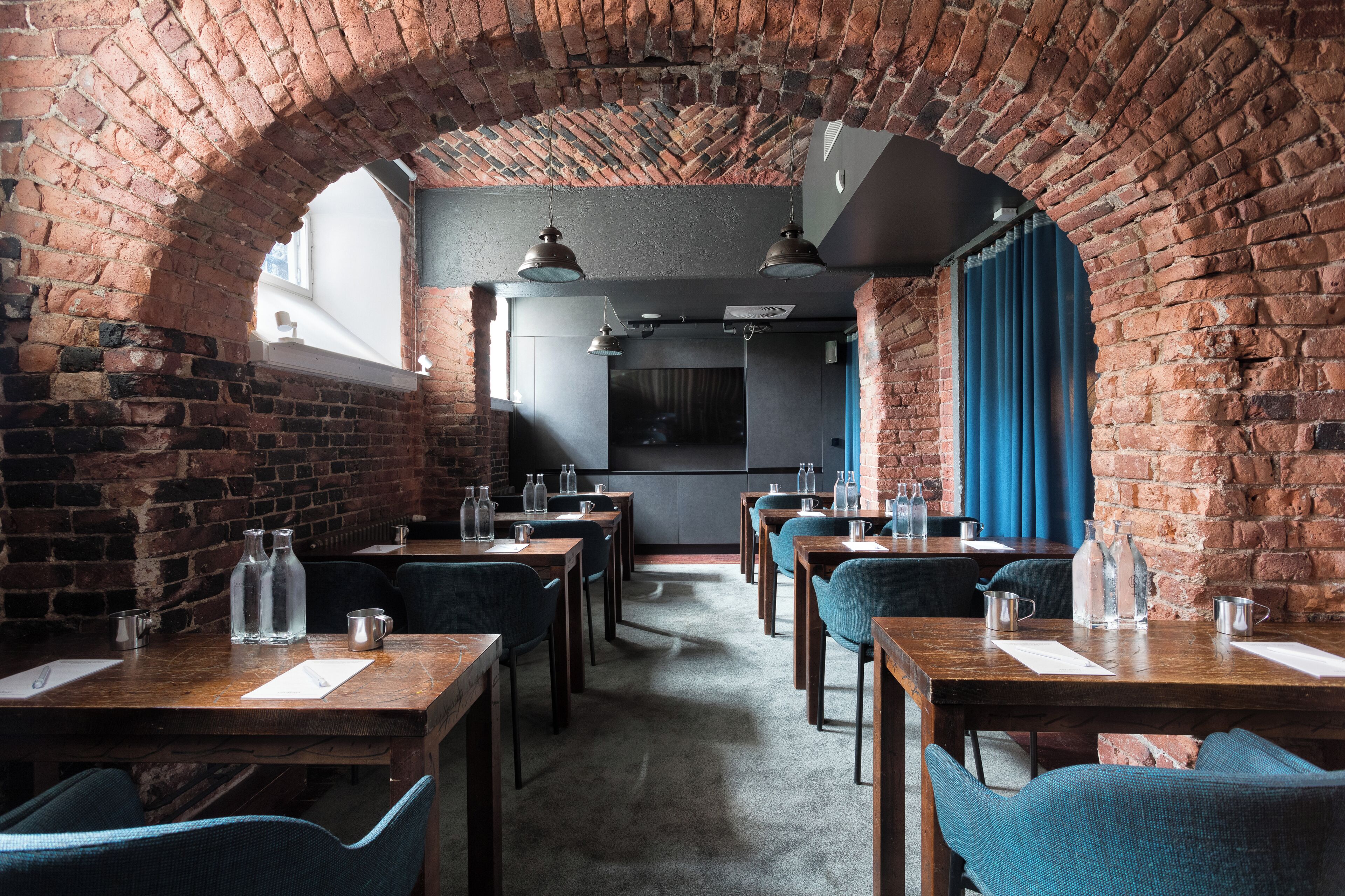 Un restaurante con paredes de ladrillo, mesas de madera y sillas azules.
