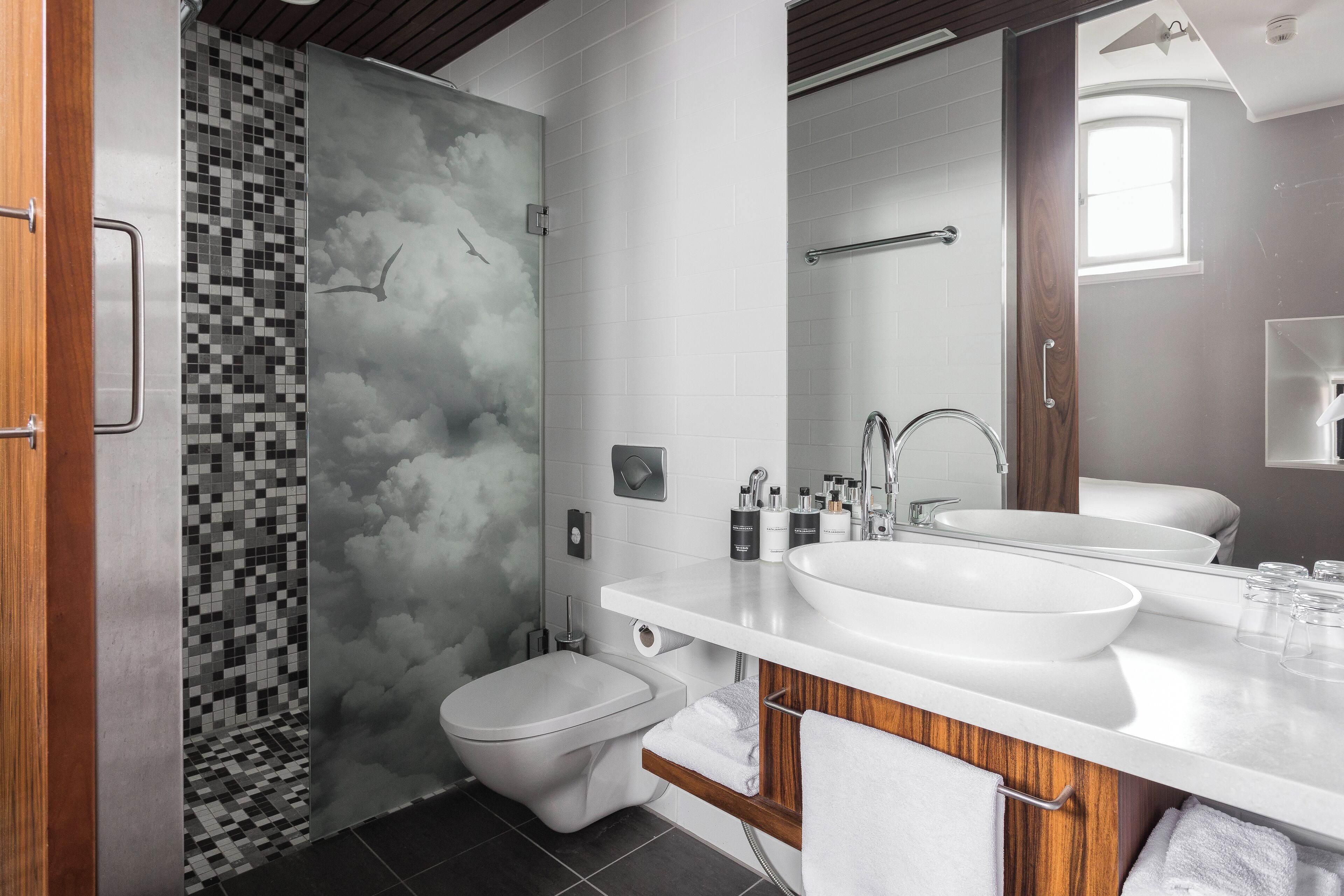 A modern bathroom with a shower, toilet, and dual sinks.