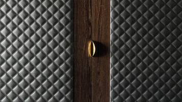 Una porta in legno con superficie strutturata e maniglia in ottone.