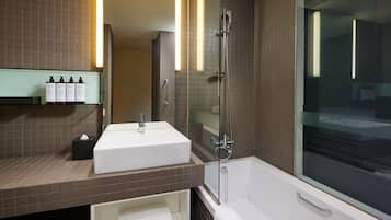 Un baño moderno con un lavamanos blanco, ducha con mampara de vidrio y un amplio ventanal.
