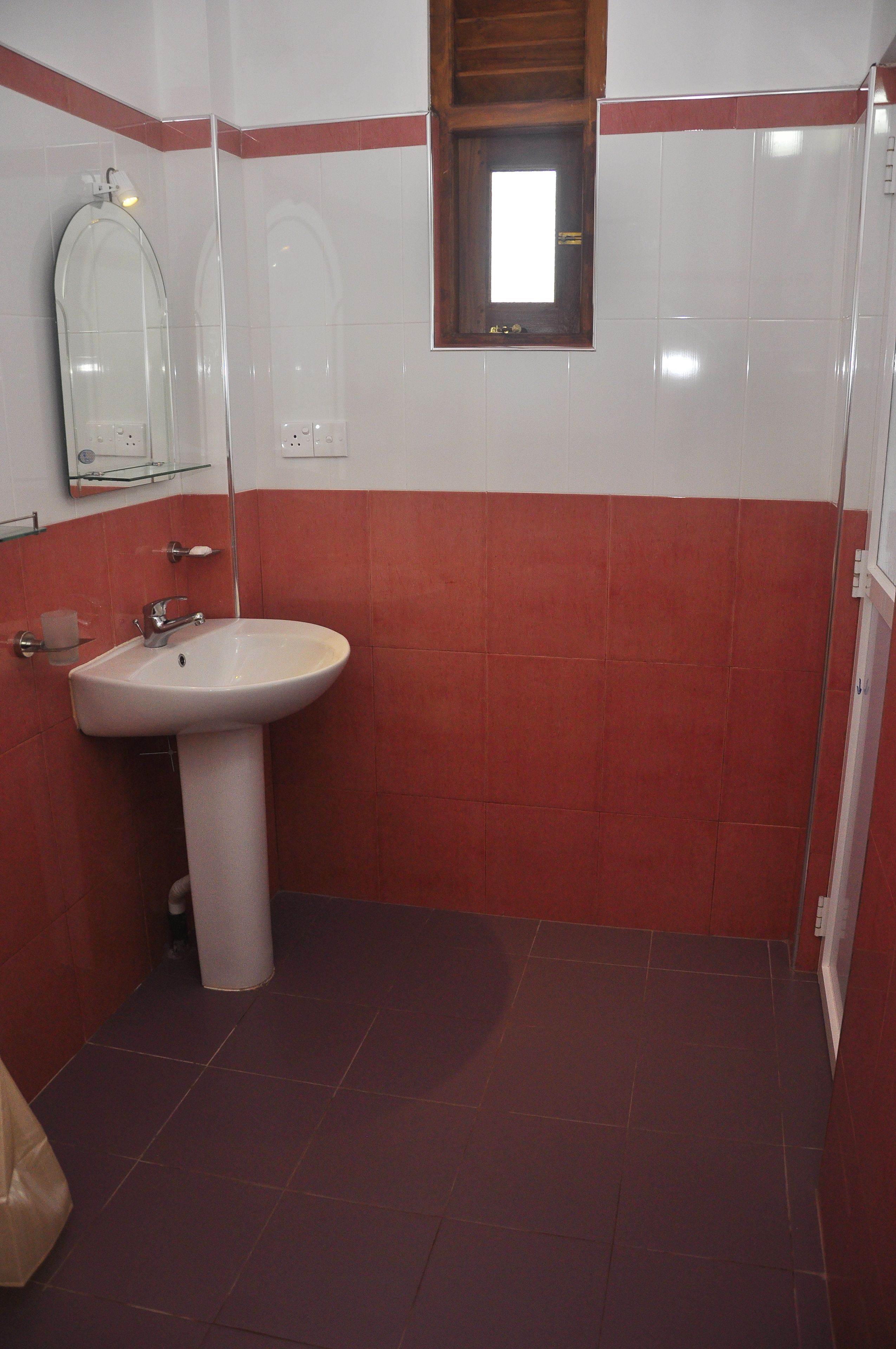 A bathroom with a sink, mirror, and a window.