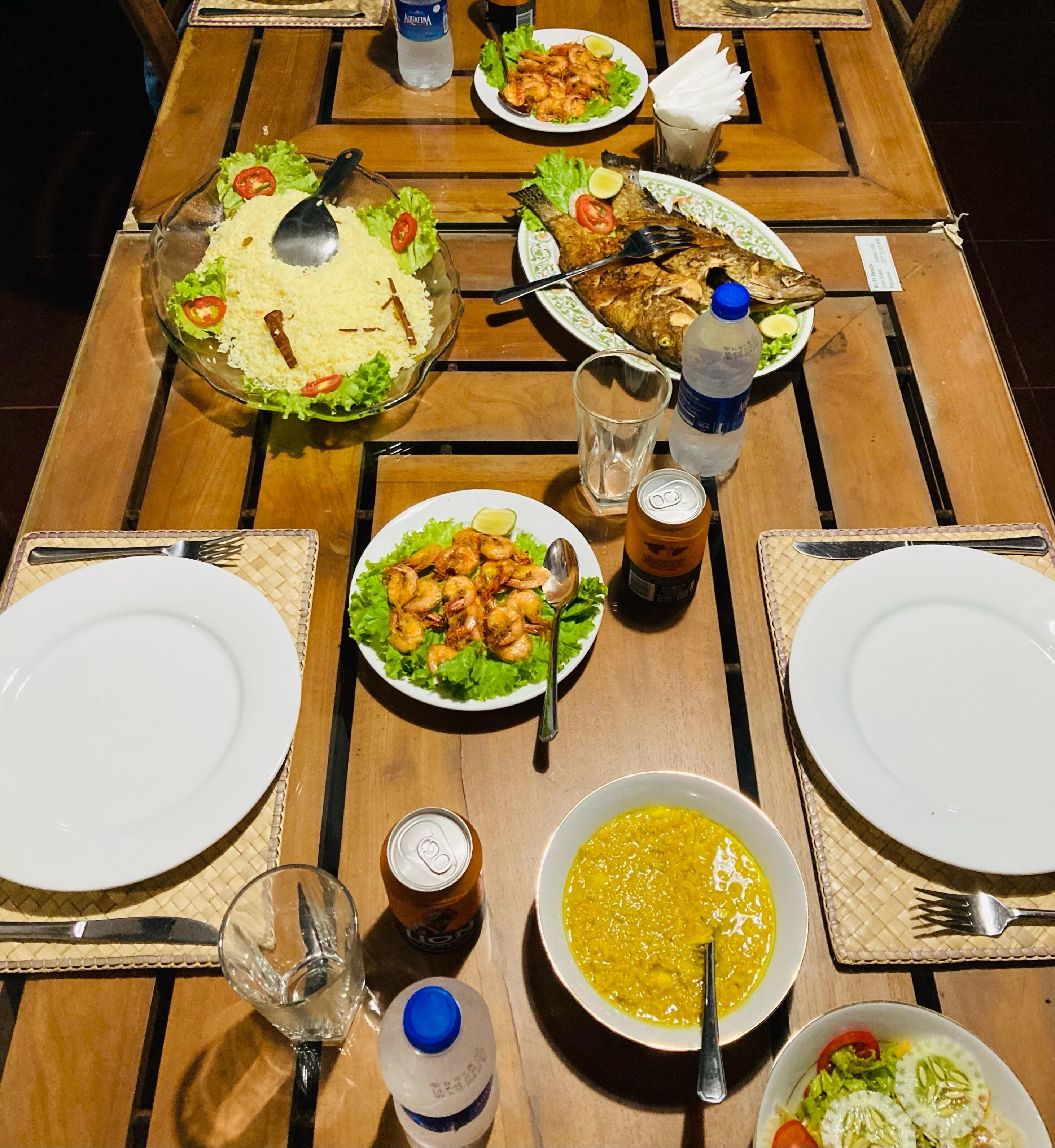 A dining table set with plates, bowls, and condiments.