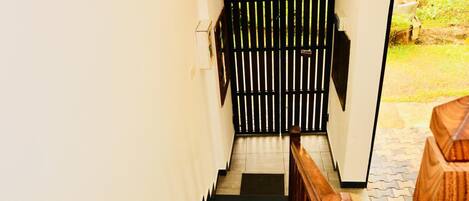 A staircase with a wooden handrail leading to a closed gate.