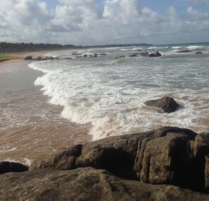 A rocky shoreline with waves crashing onto the beach. - Supunvilla (Bentota)