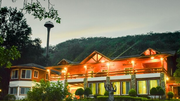 A large, multi-story building with a prominent entrance and a well-maintained lawn in front. - The Log Home Experience Khao Yai (Pak Chong)