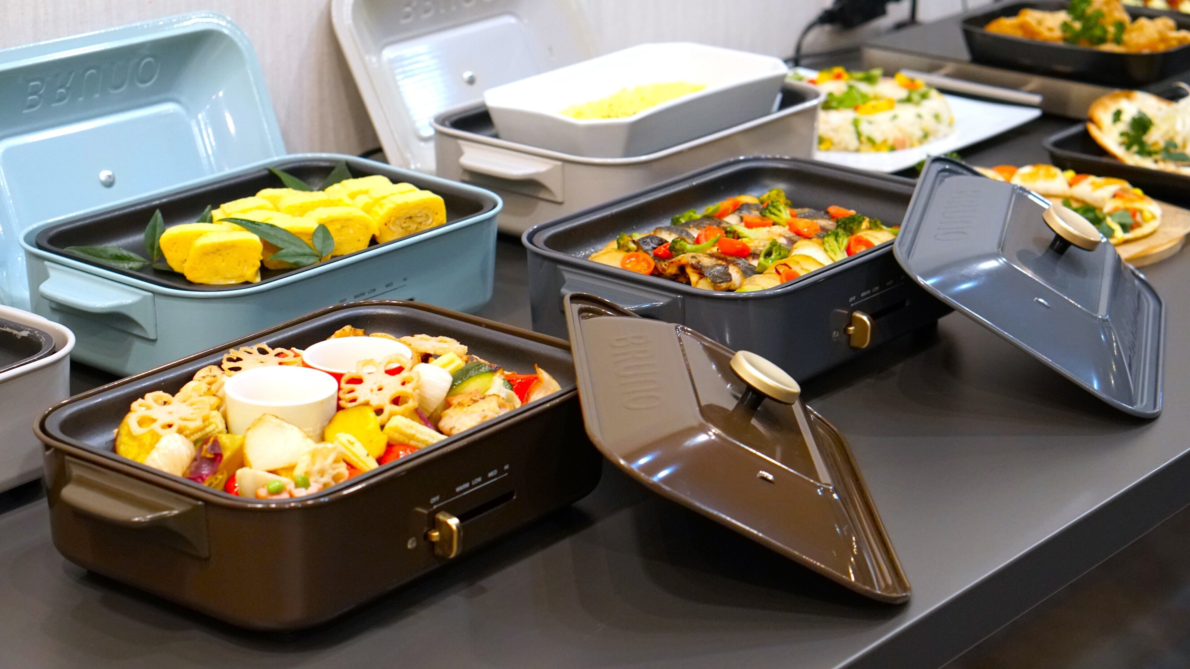 Una mesa de buffet con diversos platos de comida en diferentes recipientes.