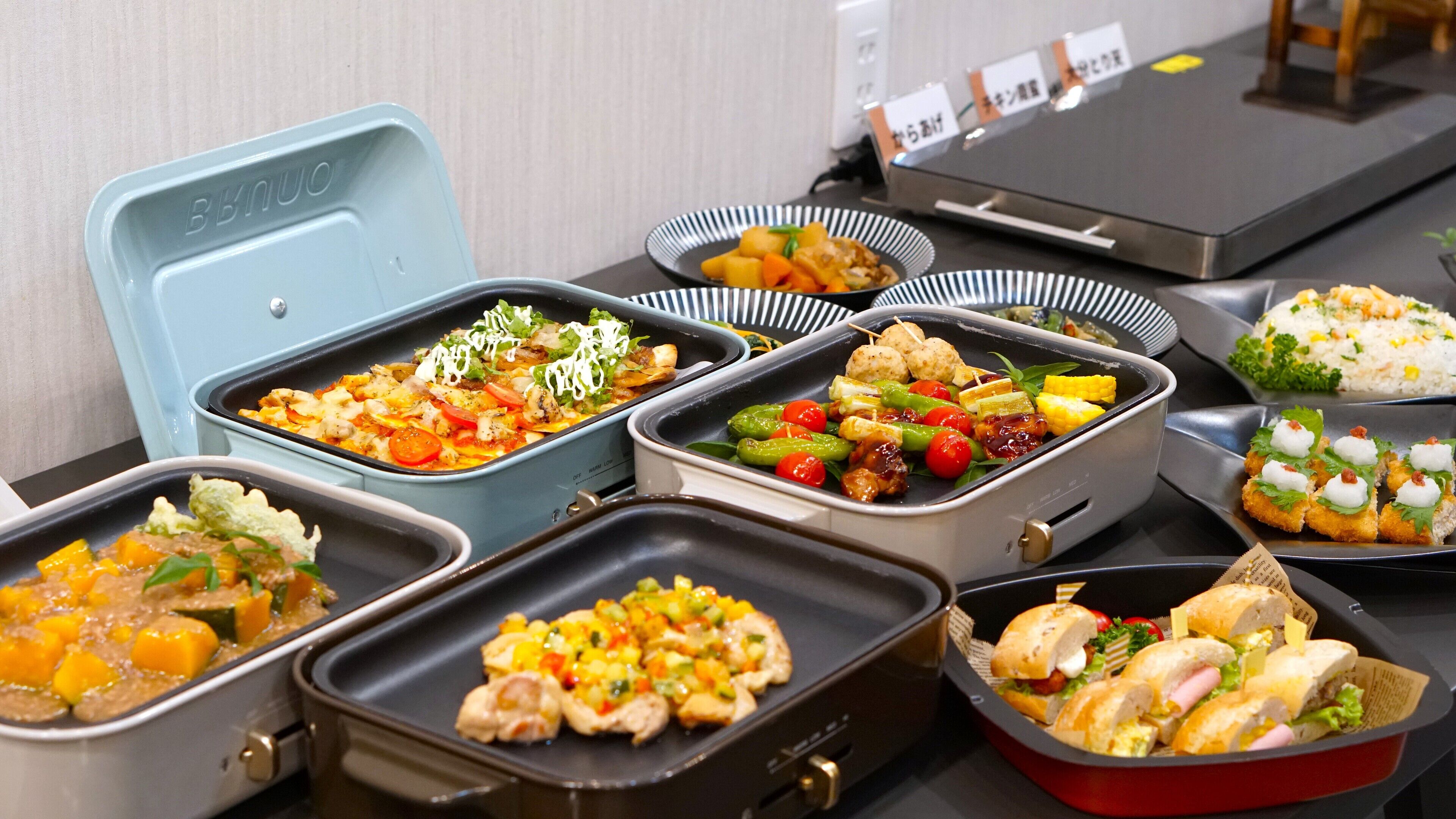 Ein reichhaltiges Buffet mit verschiedenen Speisen in unterschiedlichen Behältern.
