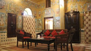 Una habitación tradicional con un conjunto de sofá, una mesa y un armario.