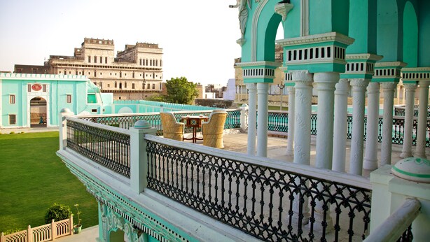 Un edificio tradicional con un balcón que presenta barandillas y columnas ornamentadas.