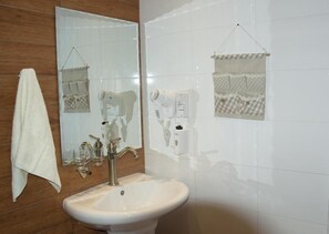 A bathroom with a sink, mirror, towel, and towel rack. - Sunrise Arches Apartments (Limassol)