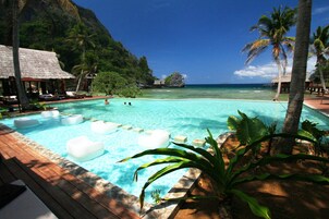 Una piscina al aire libre, tumbonas