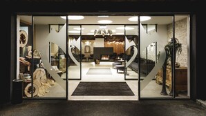 Un intérieur moderne avec une cheminée centrale, un coin salon et un escalier menant aux niveaux supérieurs.