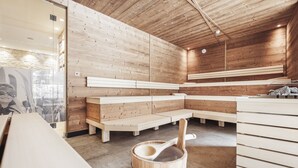 Un sauna avec des bancs en bois et un seau en bois accompagné d’une louche.