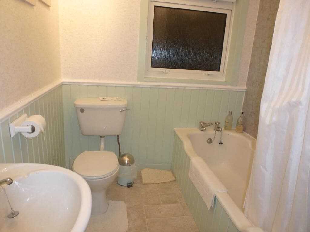 A bathroom with a toilet, sink, and bathtub.