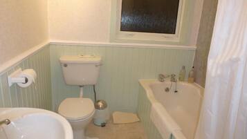 A bathroom with a toilet, sink, and bathtub.