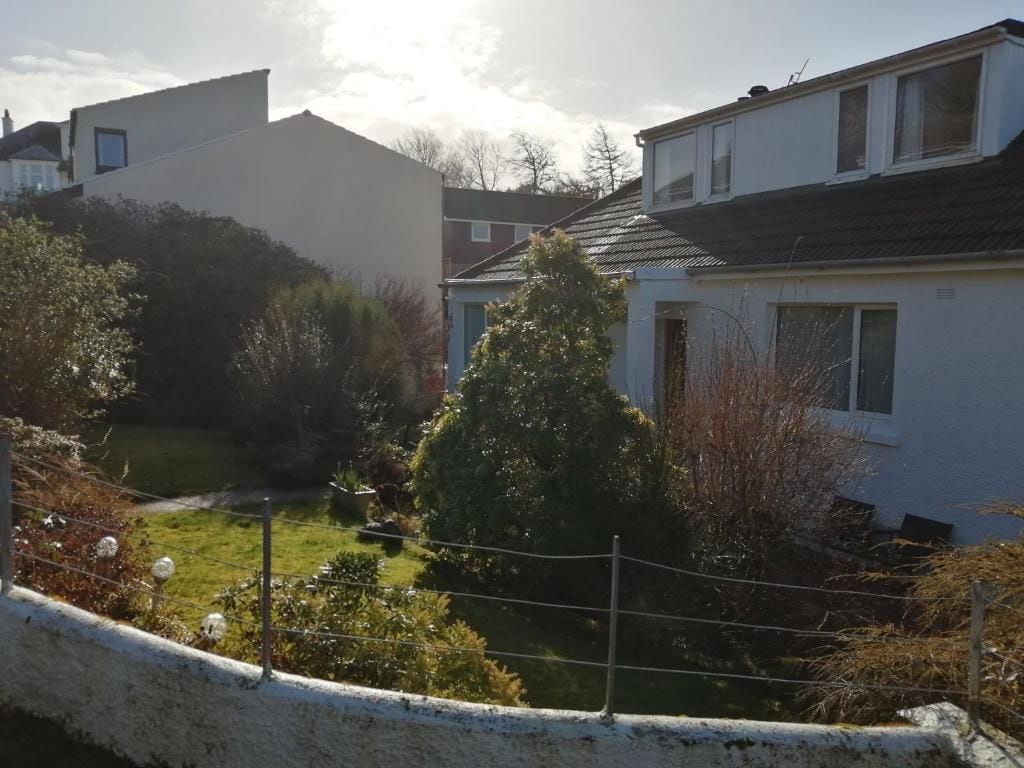 A residential area with houses, a fenced yard, and a small pond.