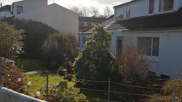 A residential area with houses, a fenced yard, and a small pond.