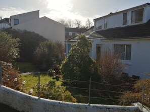 A residential area with houses, a fenced yard, and a small pond. - Don Muir Guest House (Oban)