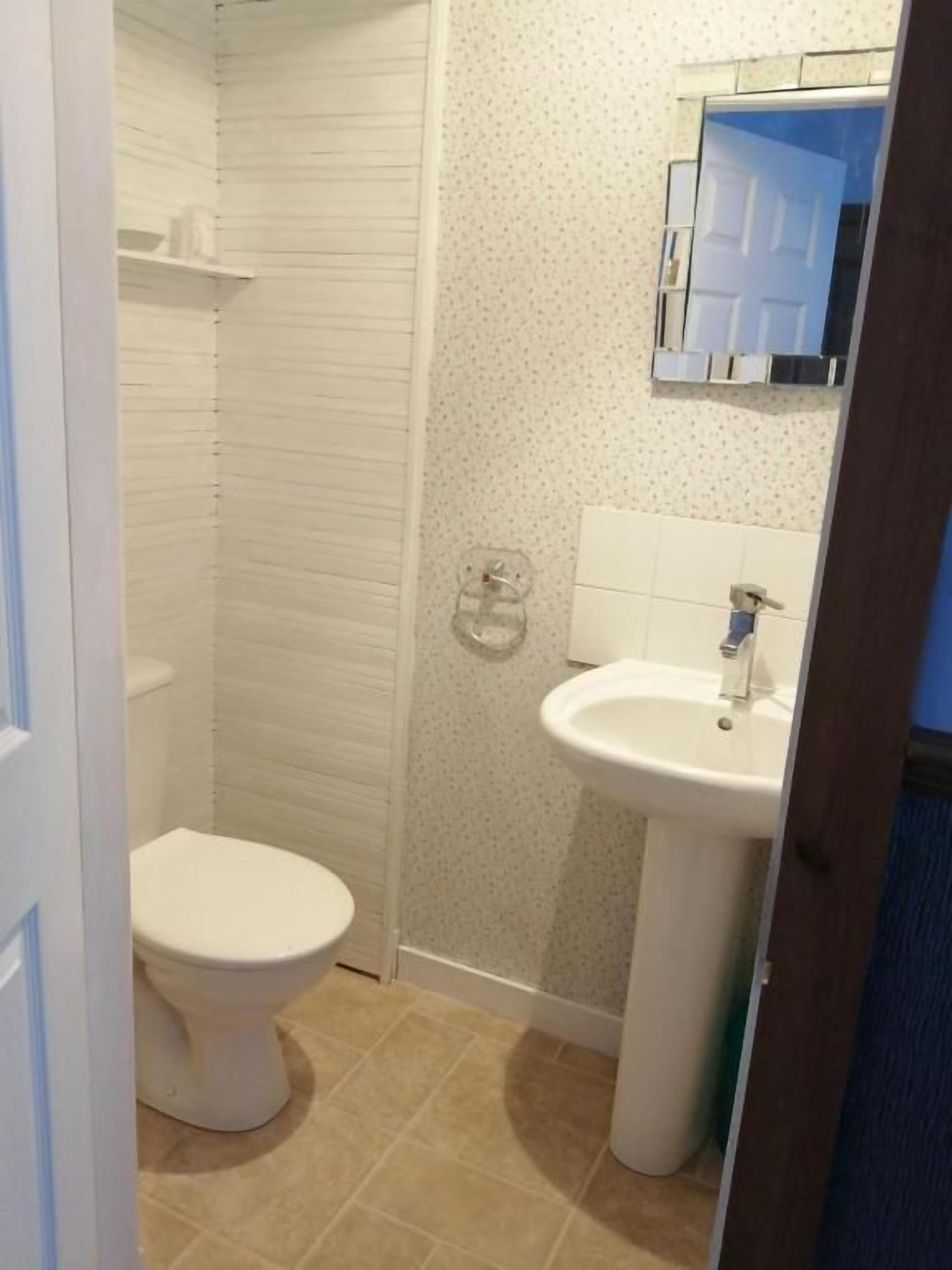 Un baño con inodoro, lavamanos y ducha.