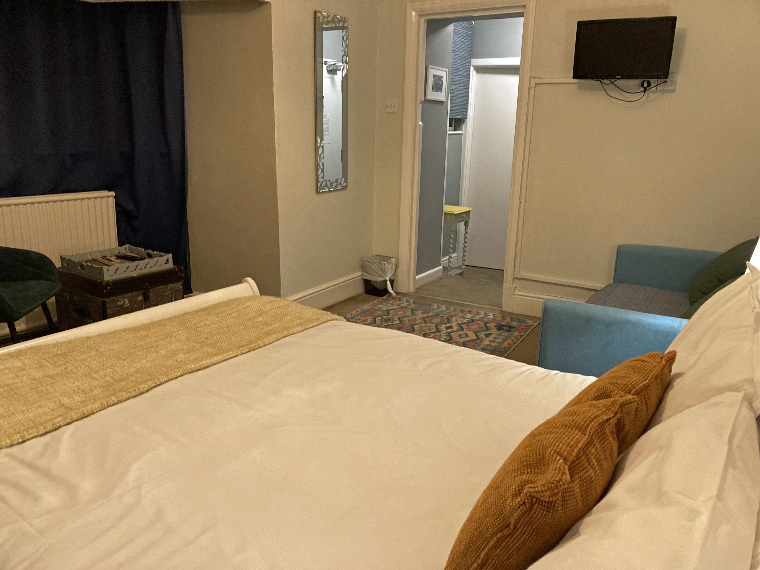 A hotel room with a bed, a chair, a television, and a small table.