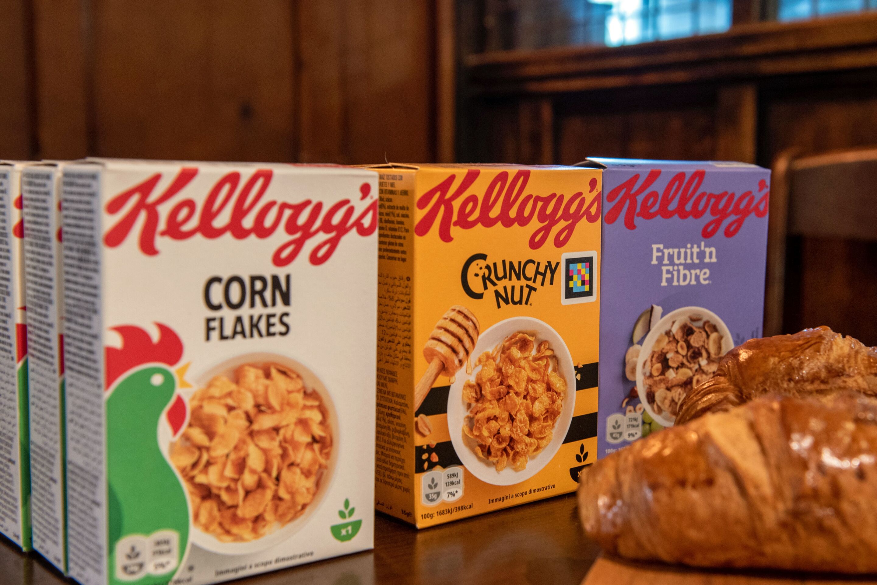 A row of Kellogg's cereal boxes on a wooden surface.