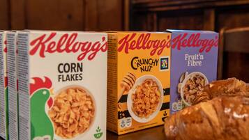A row of Kellogg's cereal boxes on a wooden surface.