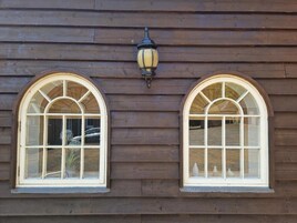 A building with two arched windows and a wall-mounted light fixture.