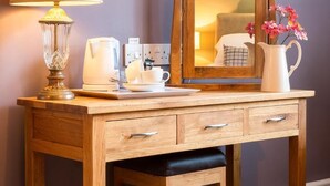 A wooden desk with a lamp, a coffee maker, a pitcher, and a mirror. - The Lounge Hotel and Bar (Penrith)