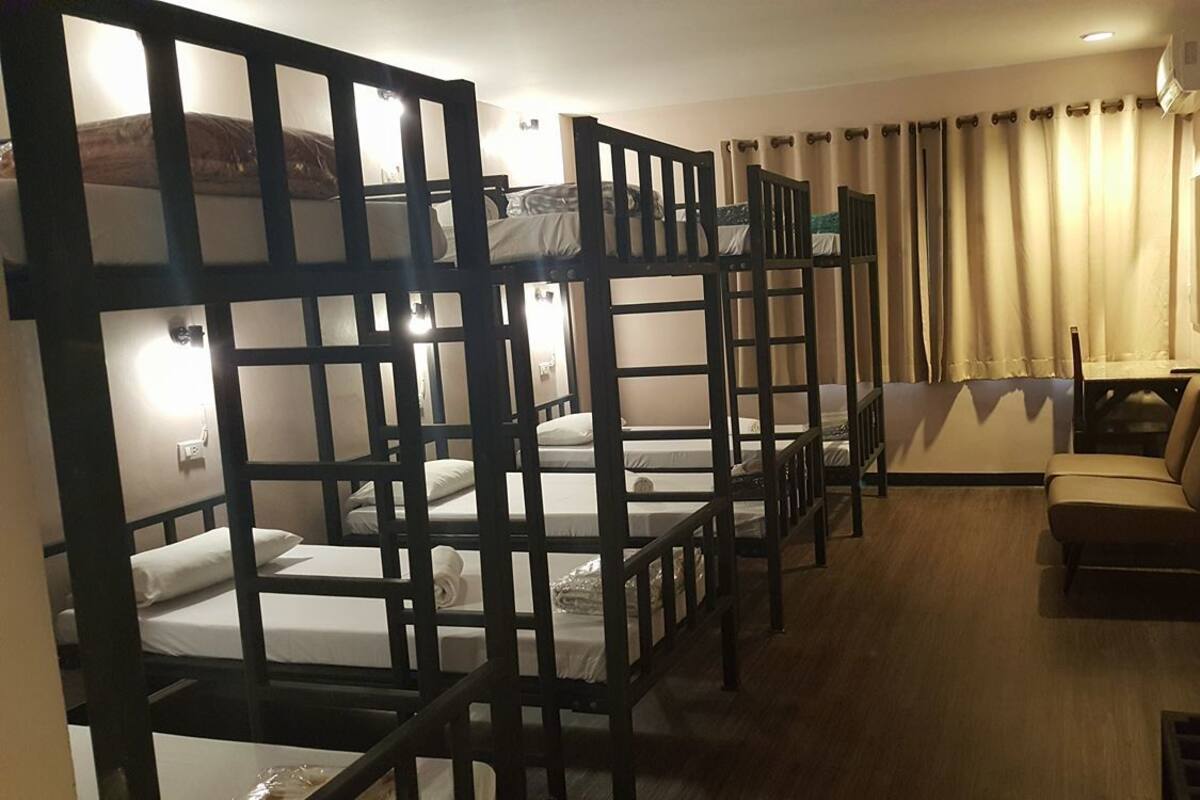 Een kamer met stapelbedden, een slaapbank en een kleine tafel.