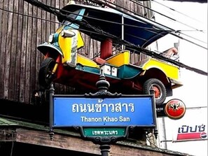 A street sign with Thai text and a blue background. - Suksawad Hotel (Bangkok)