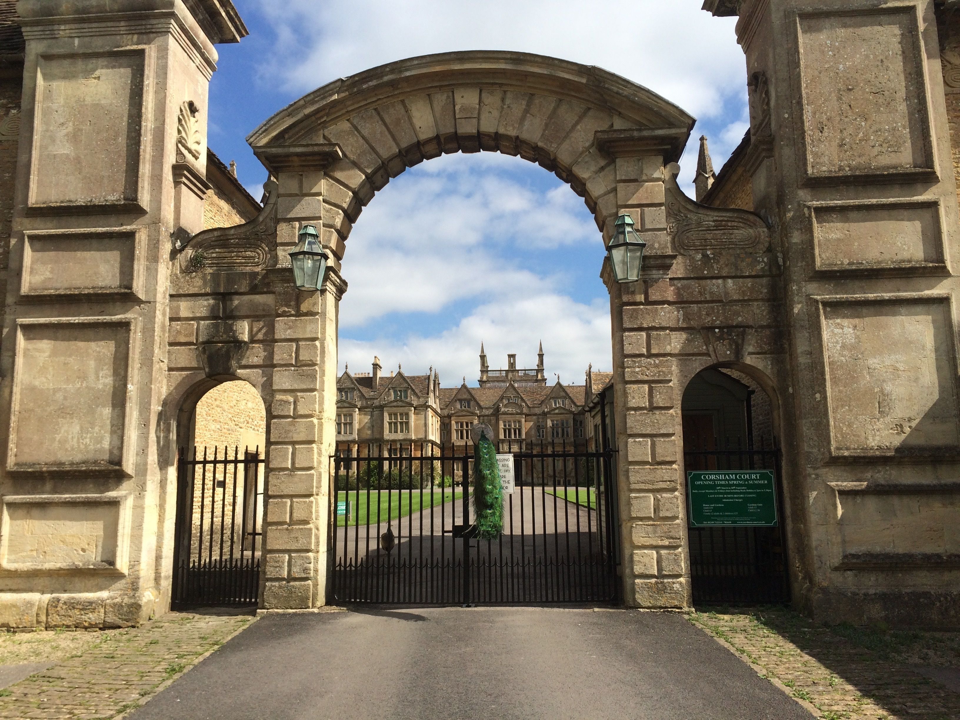 A stone archway leading to a historic building with a sign indicating 'CORSHAM COURT'.