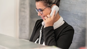 A person sitting at a desk with a telephone. - Top Floor Colosseo (Rome)