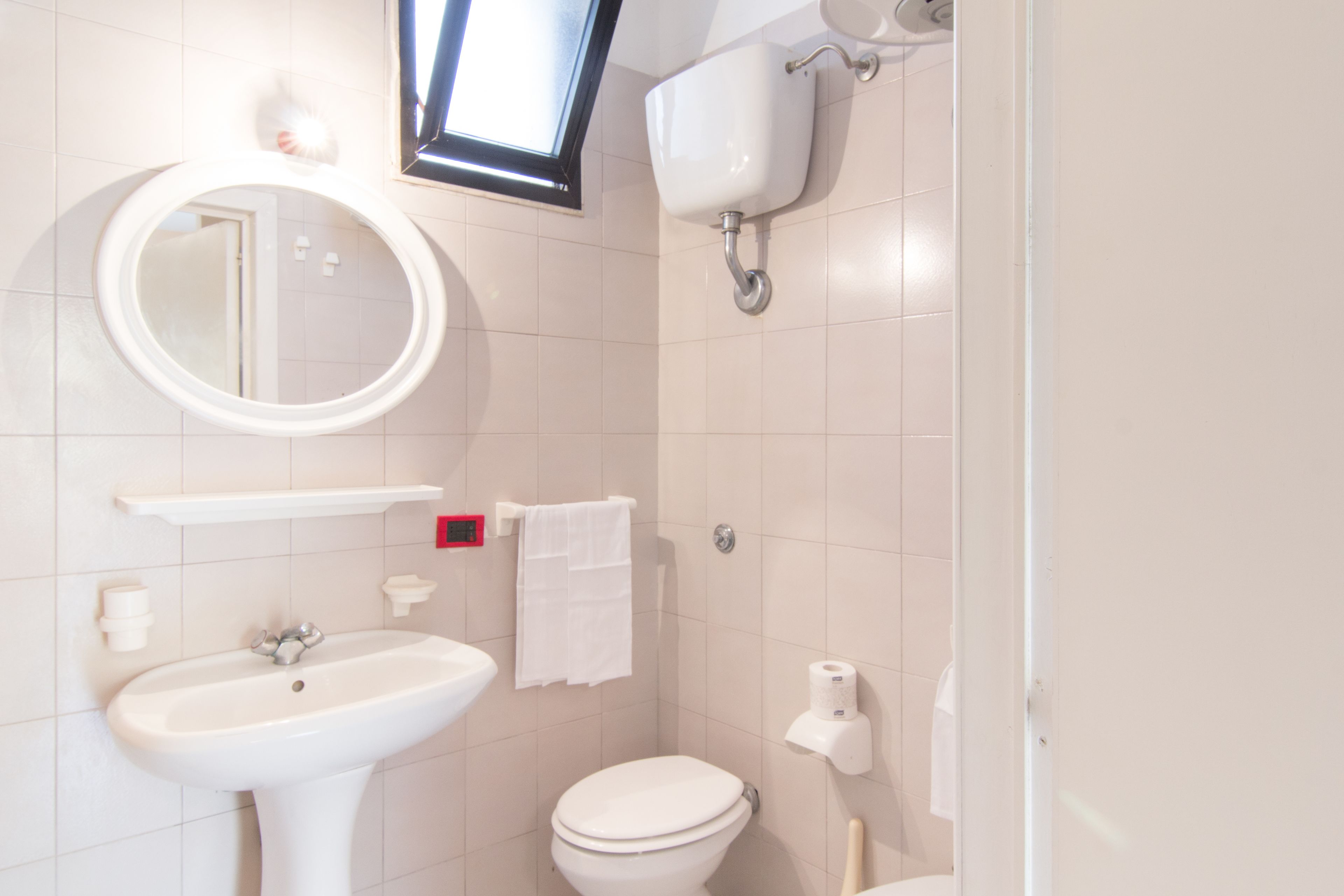 A bathroom with a sink, toilet, and mirror.