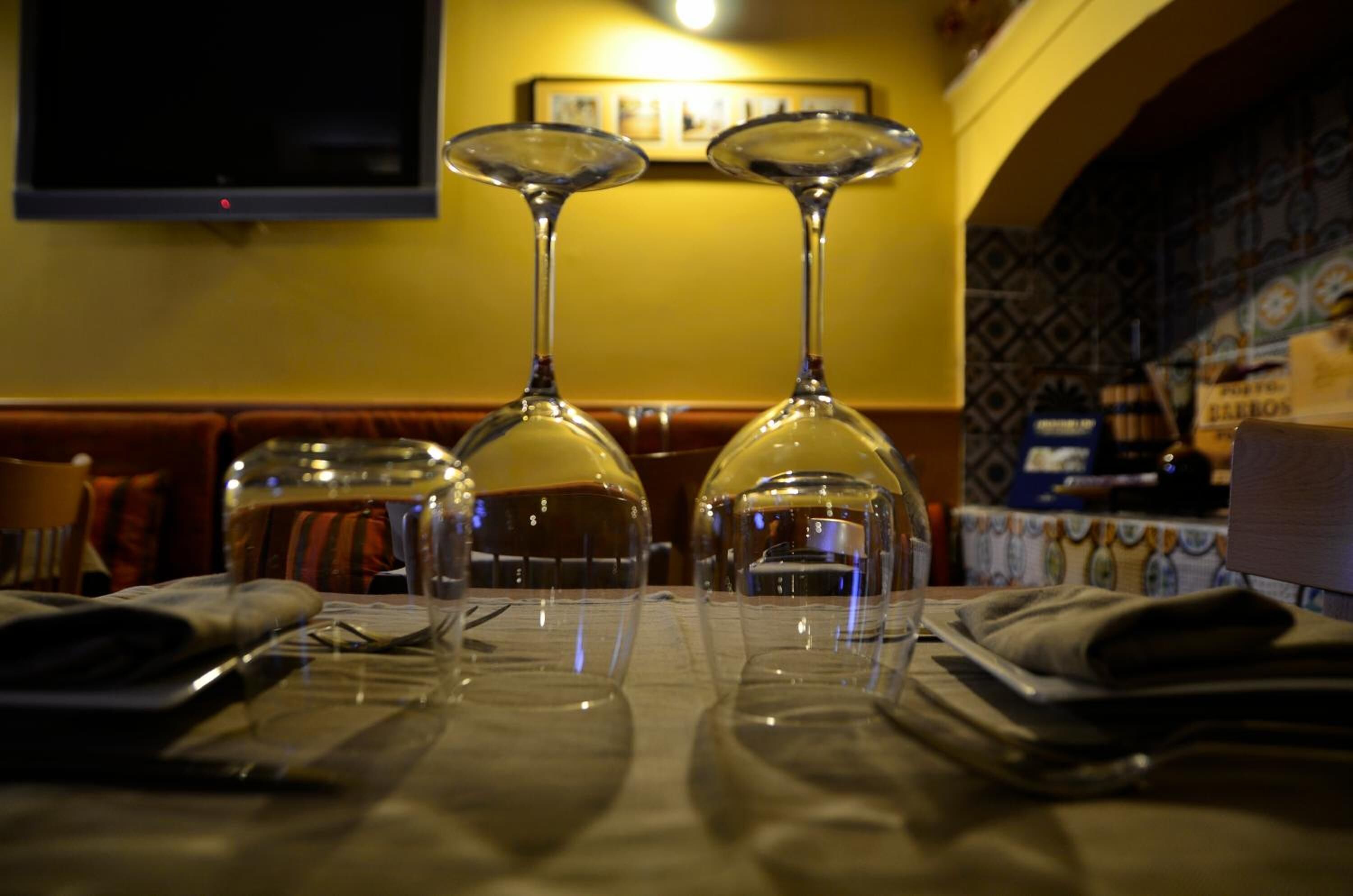 A table with two empty wine glasses and a bottle of water.