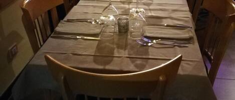 A restaurant table set with wine glasses, cutlery, and a salt and pepper shaker.