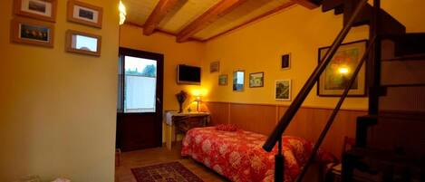 Una habitación con una cama, un escritorio, una silla, una escalera y una ventana.